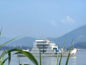 WAN-PAX-007 Ro-Ro catamaran passenger ferry underway on river with mountainous backdrop