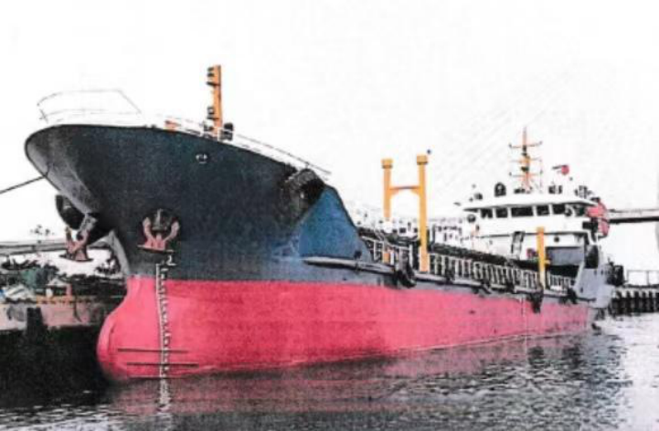 WAN-TANK-005 oil tanker with dark hull and pink bottom at berth, bow-on view