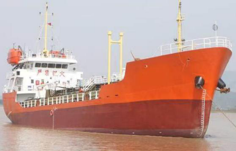WAN-TANK-007 self-propelled oil barge, orange/red hull, bow-on at berth